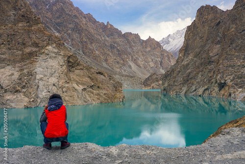 A woman watching turquoise Attabad lake , Gilgit, Pakistan