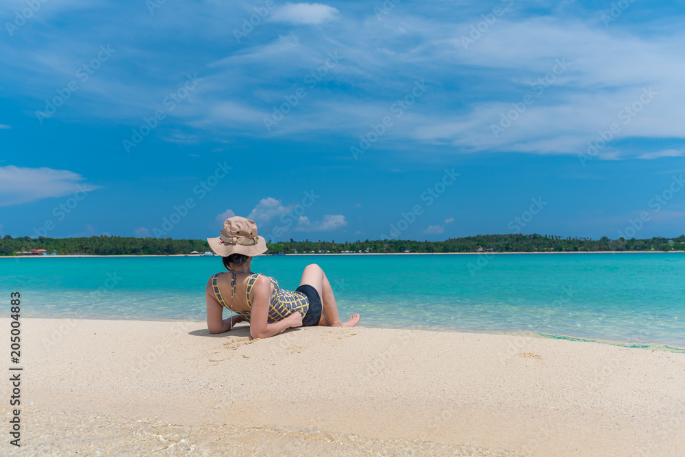 A Asian woman relaxing on beautiful beach Koh Kham island ,Trad,Thailand with blue cloud sky background A Asian woman relaxing on beautiful beach Koh Kham island ,Trad,Thailand with blue cloud sky background