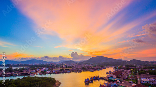 aerial scenery sunset at Siray fishing port. Phuket Fishing Port is the largest fishing port. Located in Sire Island, next to Phuket Island. There is a large canal leading to the sea. © Narong Niemhom