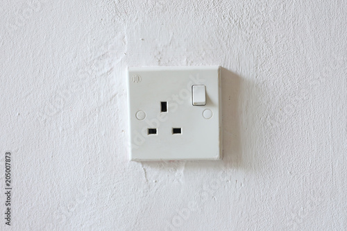 White wall socket on wall, unplug or plugged in concept.Vertical power electric plug outlet.