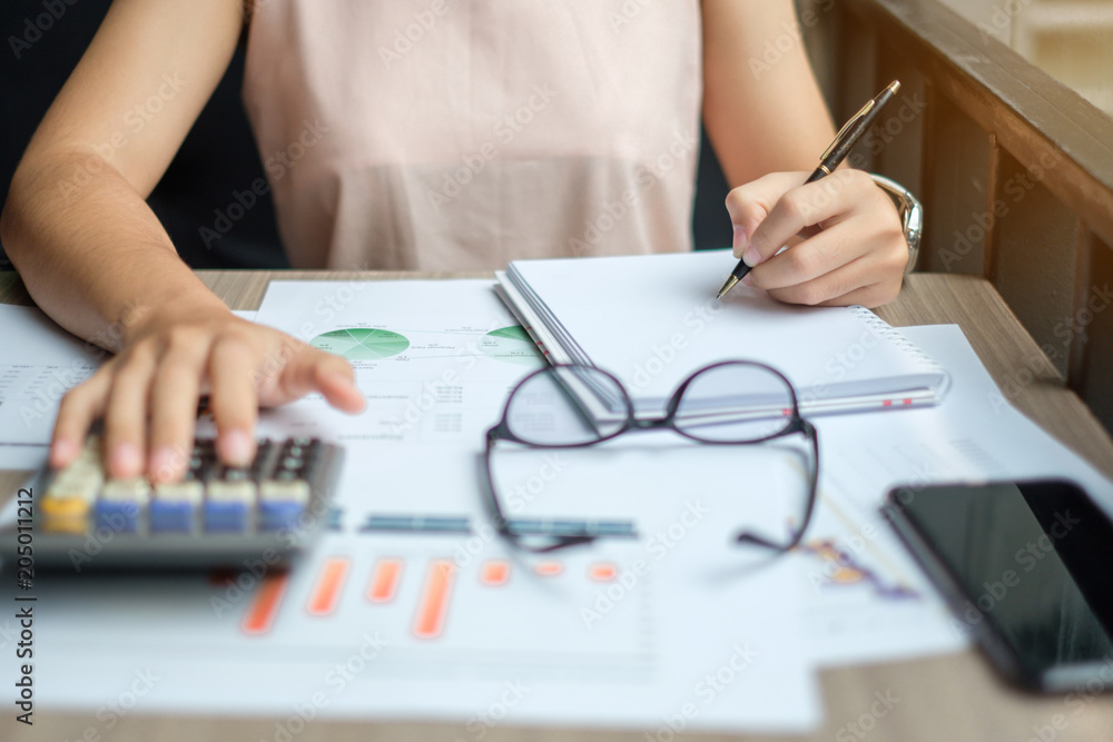 Businesswoman analysis maketing plan, Accountant calculate financial report, with graph chart. Business, Finance and Accounting concepts Businesswoman analysis maketing plan, Accountant calculate financial report, with graph chart. Business, Finance and Accounting concepts