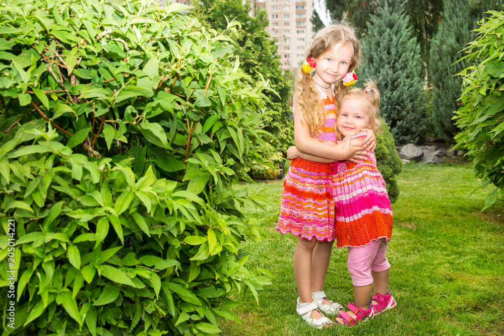 Portrait of happy adorable two sisters children girls outdoor. Cute little kid in summer day Portrait of happy adorable two sisters children girls outdoor. Cute little kid in summer day