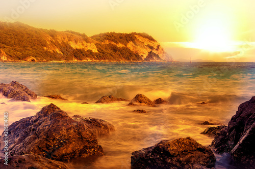 sunset beach with silhouette of tree and mountain