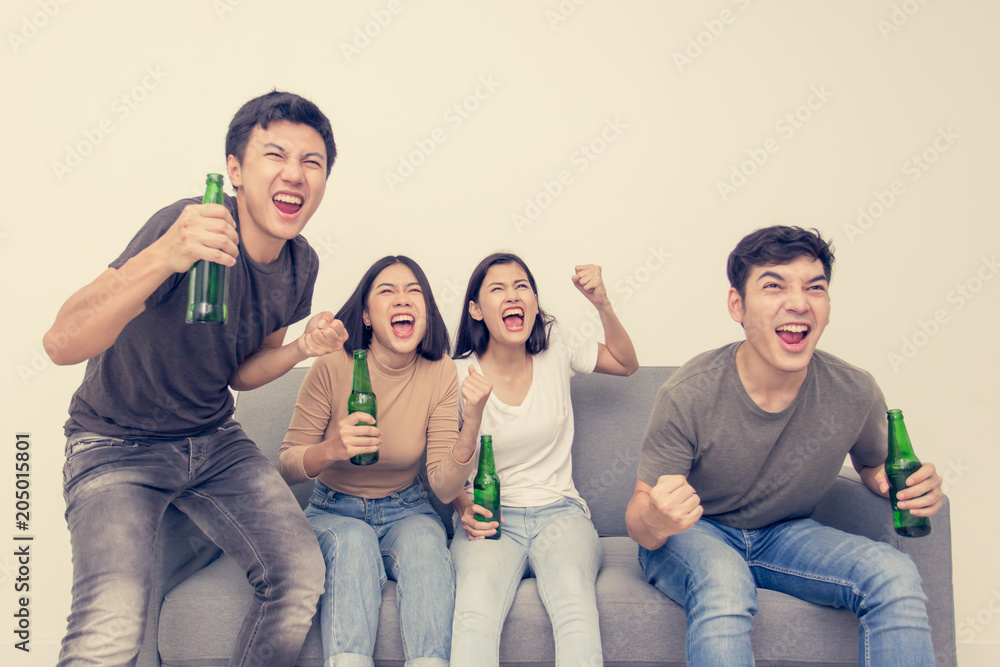Young asian people watching television together. People wacth world cup soccer with happy emotion. People with lifestyle, entertainment, happiness concept.