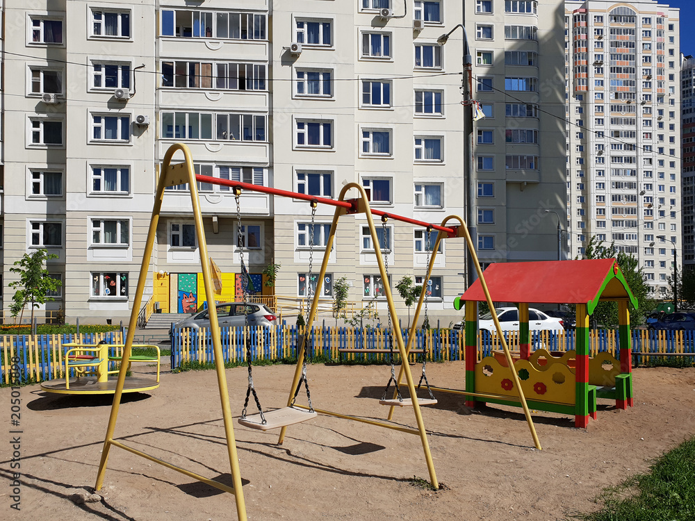 children's playground with swings in courtyard of residential building in the city, Russia children's playground with swings in courtyard of residential building in the city, Russia