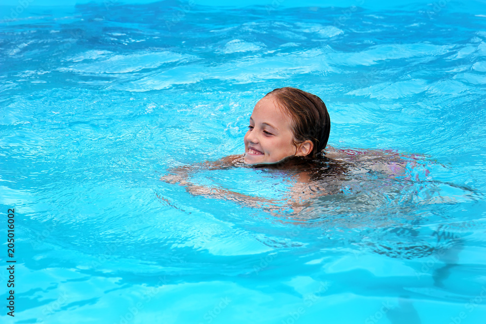 smiling little girl swimming in the pool