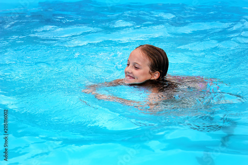 smiling little girl swimming in the pool