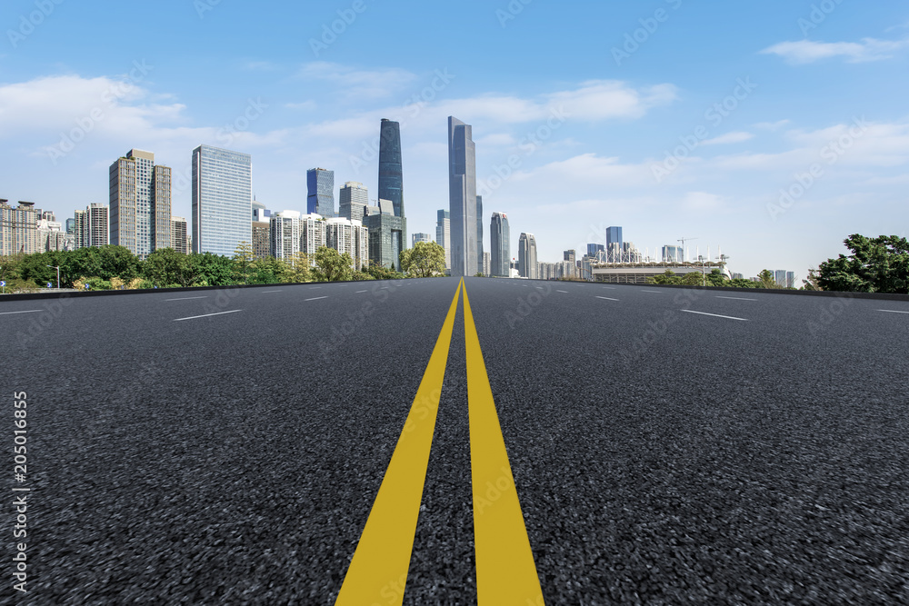 Fototapeta premium The empty asphalt road is built along modern commercial buildings in China's cities.