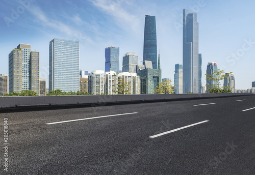 The empty asphalt road is built along modern commercial buildings in China s cities.