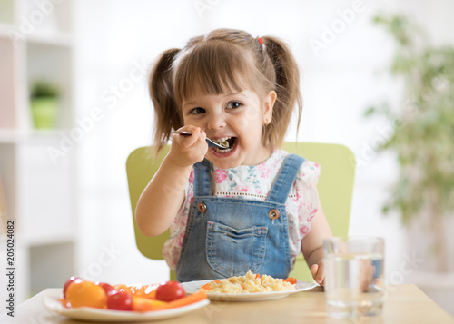 kid child girl eating healthy food at home