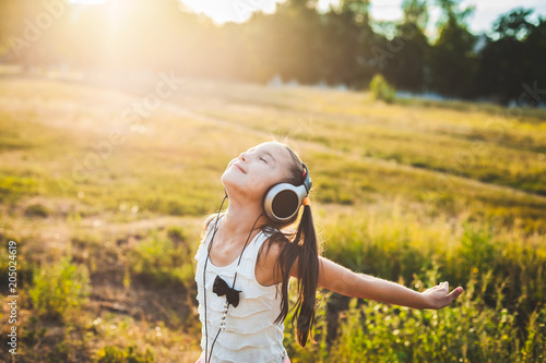 Pretty girl listening music with headphones and having rest, lucky child listening music and resting