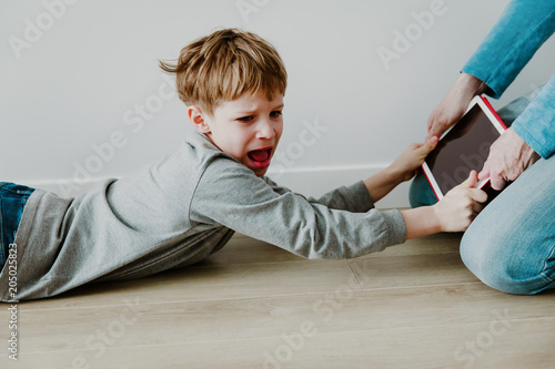 computer addiction- father taking touch pad from angry child