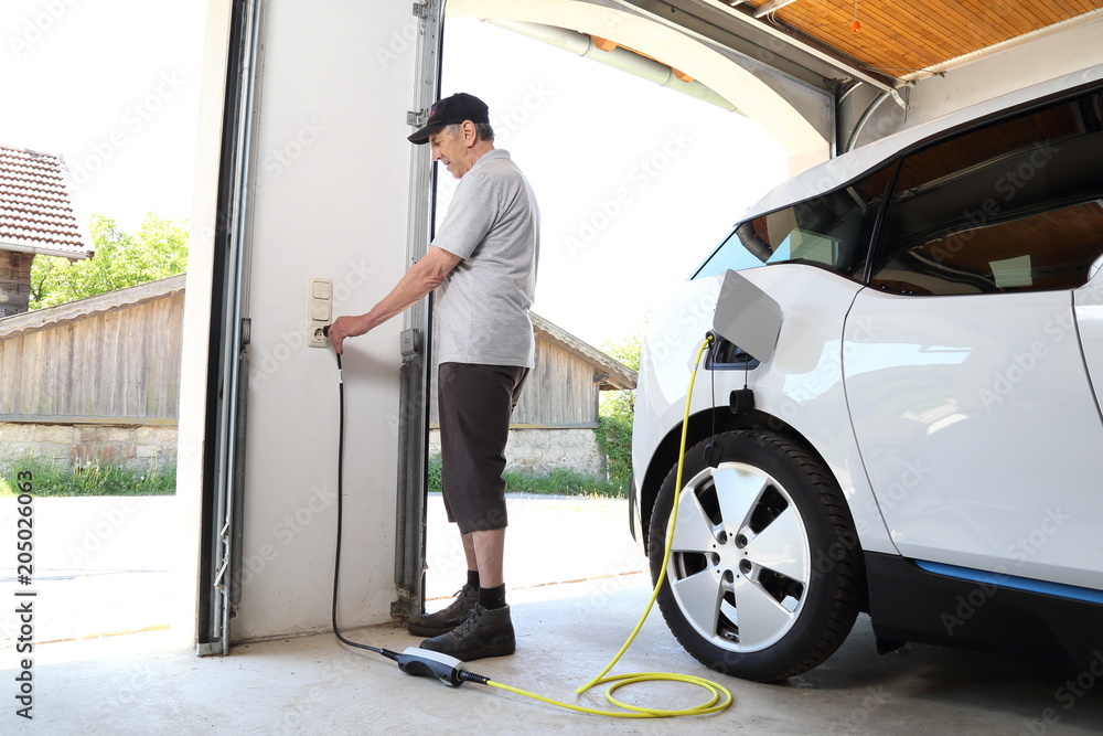 Aufladen eines Elektroautos an Steckdose Stock Photo | Adobe Stock