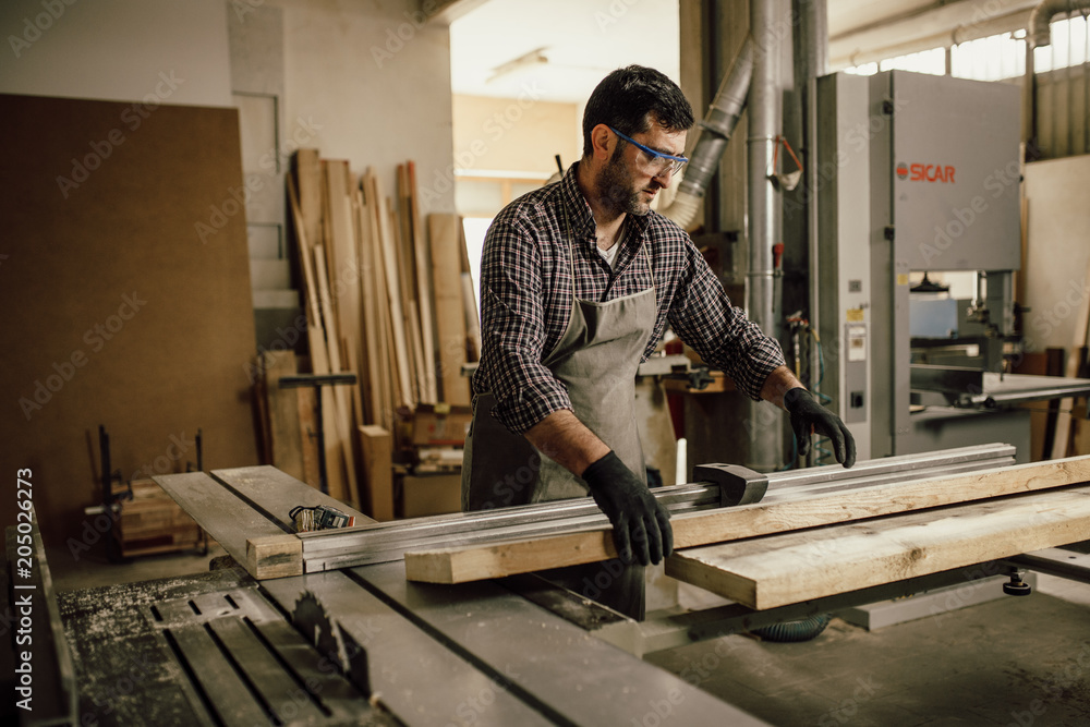 Carpenter working with circular saw at carpentry workshop