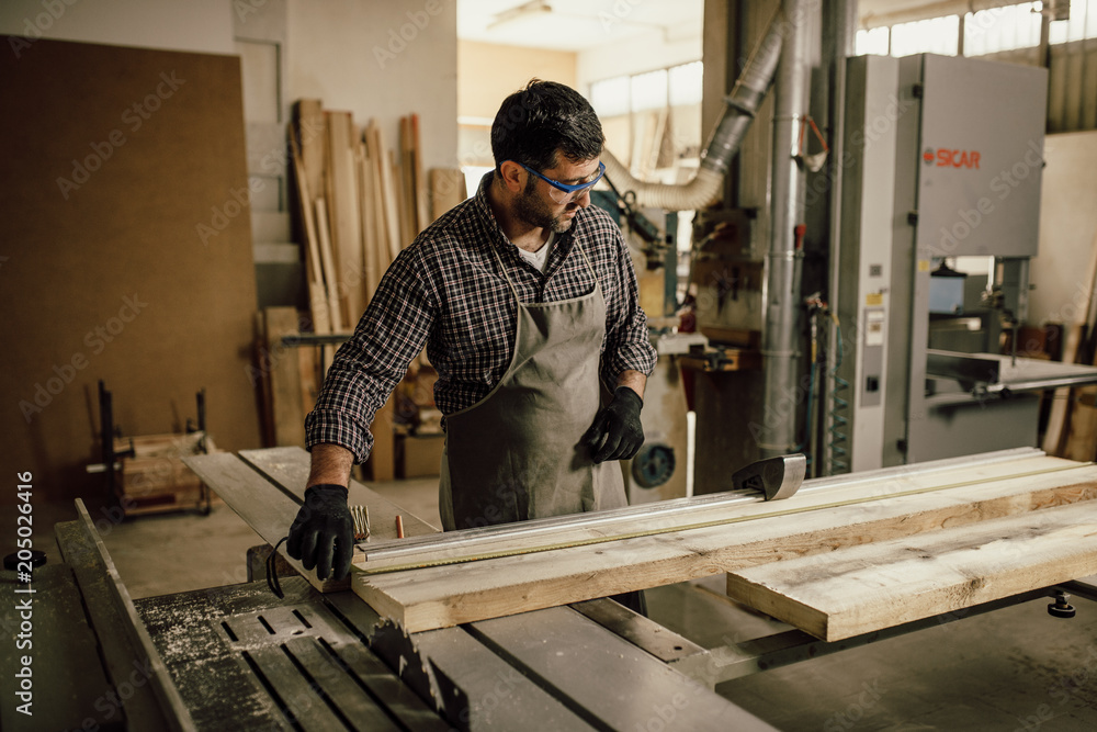 Carpenter working with circular saw at carpentry workshop Carpenter working with circular saw at carpentry workshop