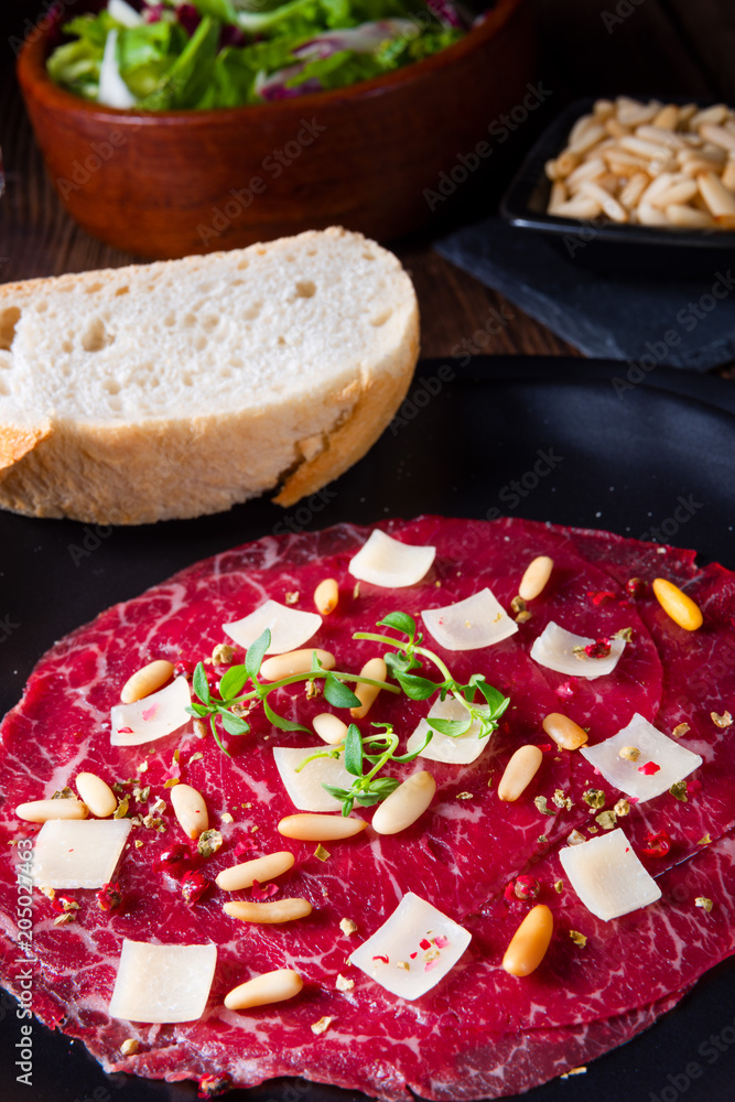 Carpaccio of beef with pine nuts, colorful pepper and Parmesan cheese