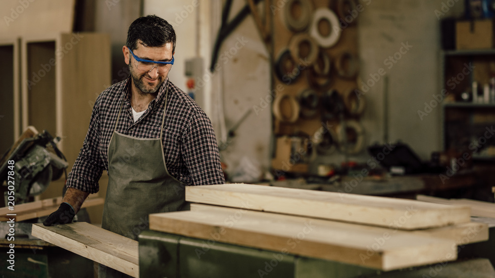 Carpenter working with circular saw at carpentry workshop Carpenter working with circular saw at carpentry workshop