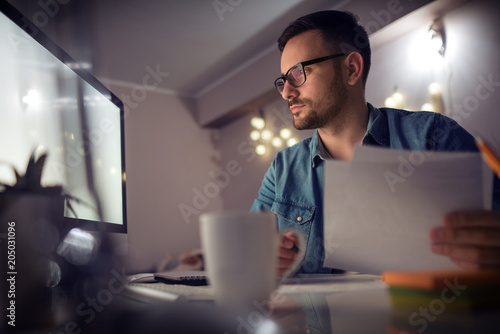 Man working on computer at home at night