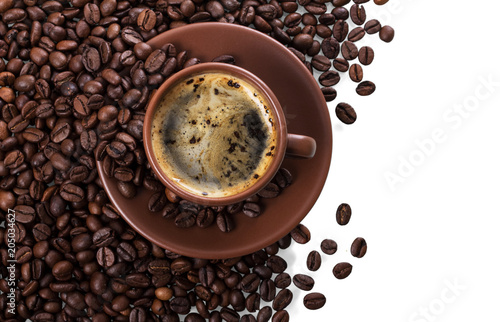 Cup of freshly brewed coffee on pile of coffee beans isolated on white
