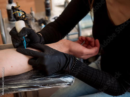 Professional tattoo artist makes a tattoo on a man