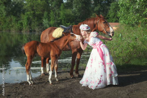 Woman with a horse and a foal. © silkstocking