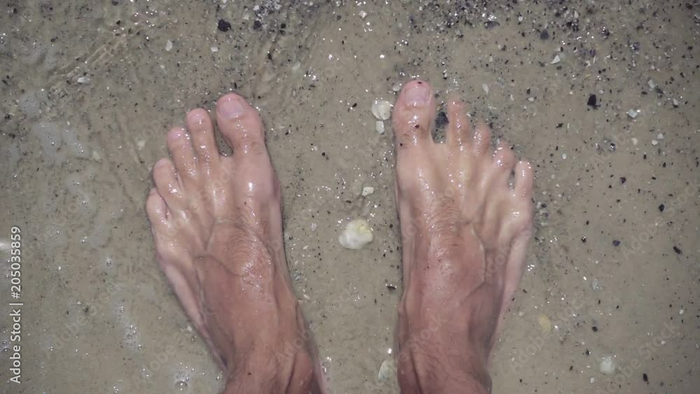 Closeup of male feet in clear sea water on beach. Closeup of male feet in clear sea water on beach.