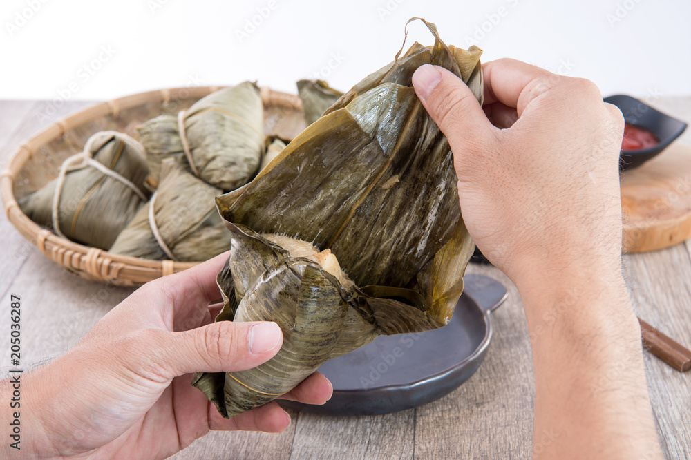 A man is going to eat zongzi or rice dumpling on Dragon Boat Festival, Asian   traditional food