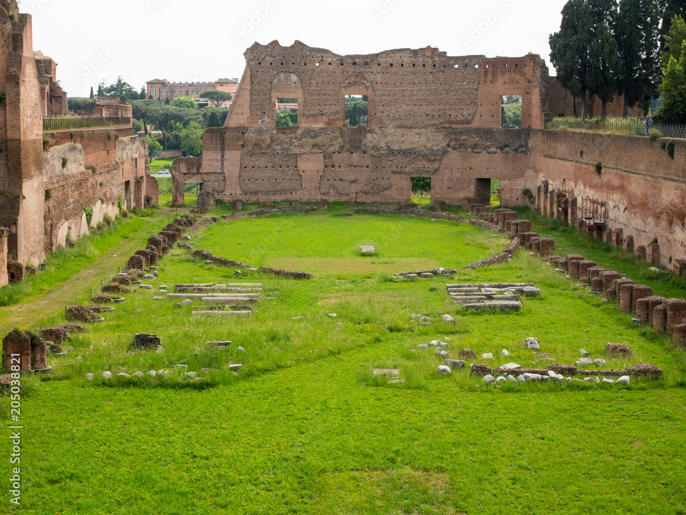 view on ruins of an old circus with green lawn in the center of Rome, Italy