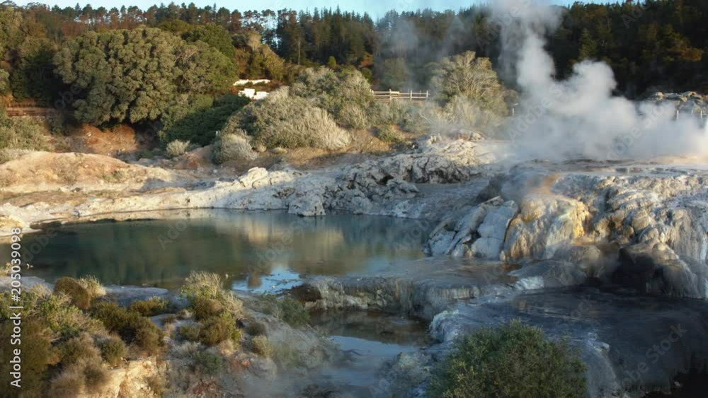 Drone shot of steaming geyser beside lake in Rotorua Drone shot of steaming geyser beside lake in Rotorua