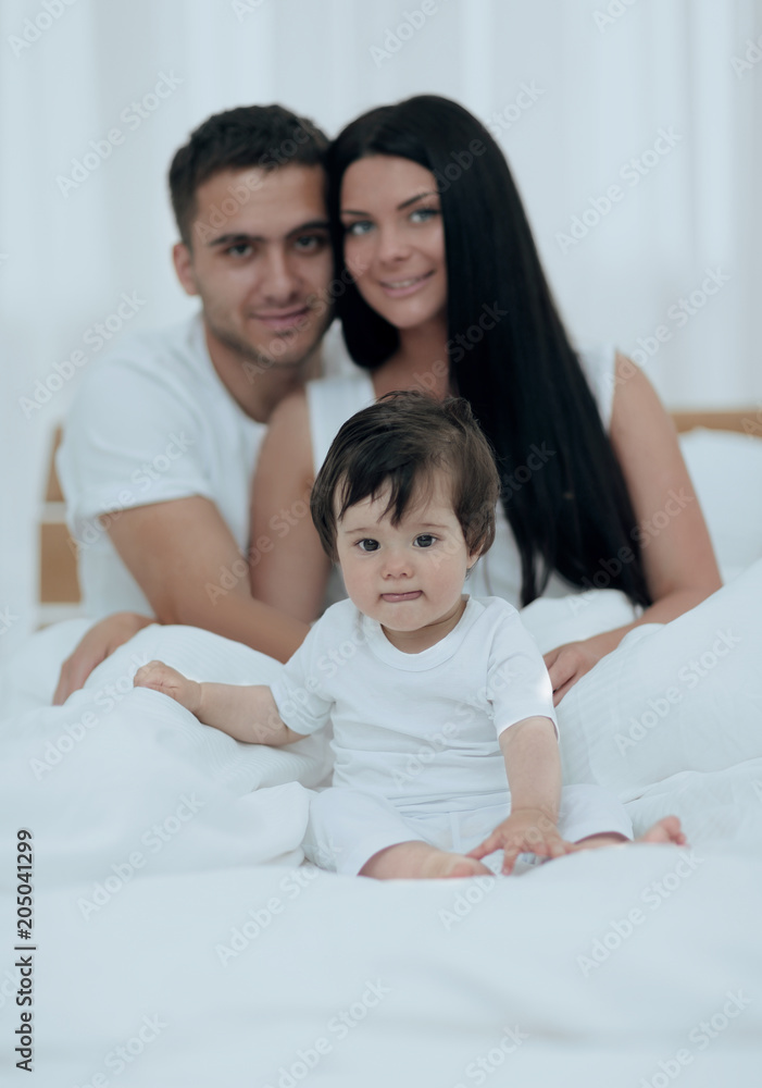 Portrait of a joyful family sitting on the bed at home Portrait of a joyful family sitting on the bed at home