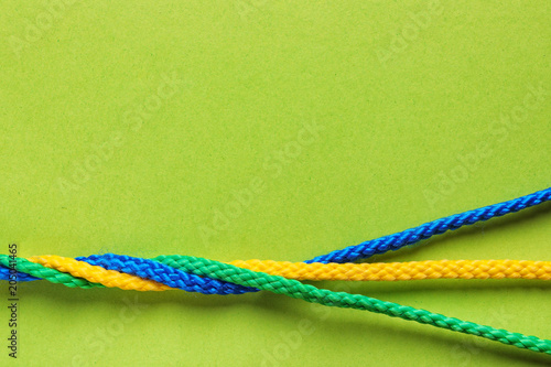 Twisted ropes on color background, top view. Unity concept