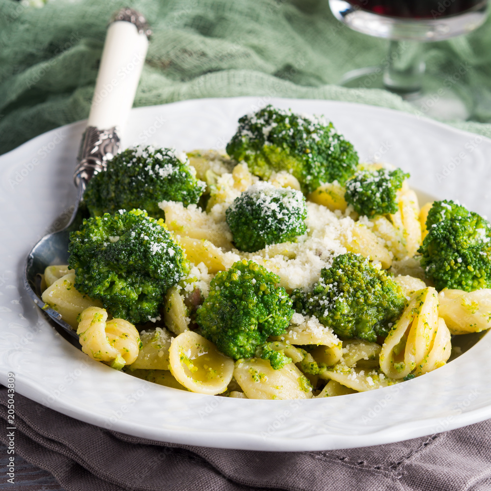 Orecchiette pasta with broccoli in white dish on wooden table. Easy recipe for lunch. Orecchiette pasta with broccoli in white dish on wooden table. Easy recipe for lunch.