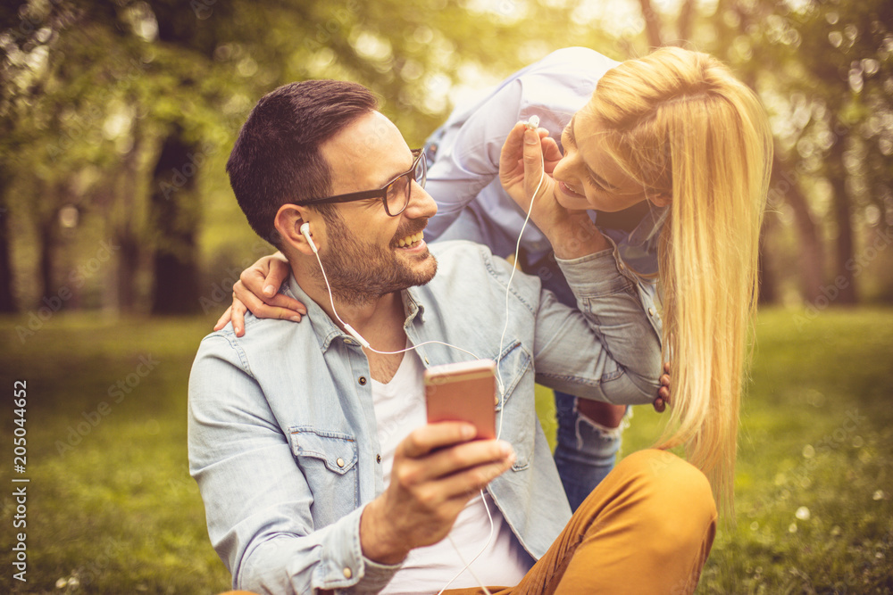 Couple listening music at park.