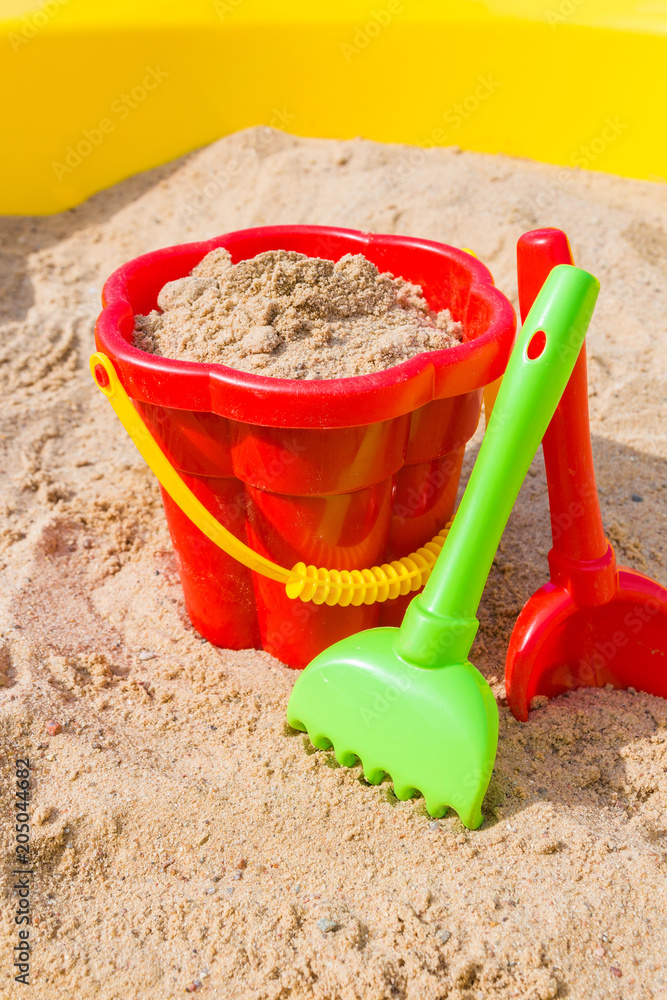 children's sandbox and colorful plastic toys pail bucket and rake for playing outdoors in the summer day concept of development and recreation of children with copy space children's sandbox and colorful plastic toys pail bucket and rake for playing outdoors in the summer day concept of development and recreation of children with copy space