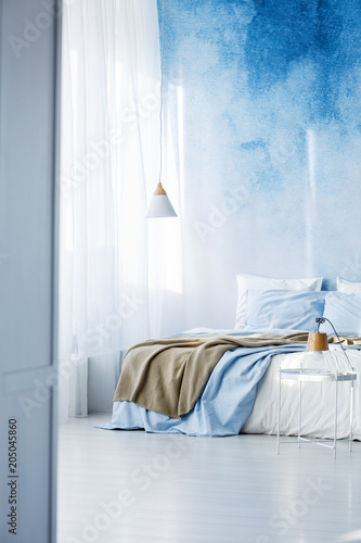 Bright bedroom interior with double bed, beige blanket and ombre wall © Photographee.eu