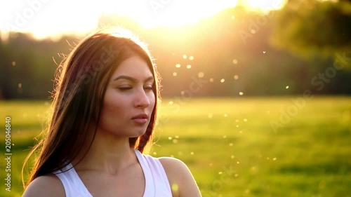 Young beautiful woman listening music at park while running. Portrait of smiling sporty girl with earphone looking at camera at park in autumn. Woman athlete looking at camera during winter sunset. photo