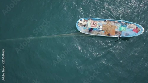 4k aerial of fishermen throwing a drift fishing net in the sea from a blue boat photo