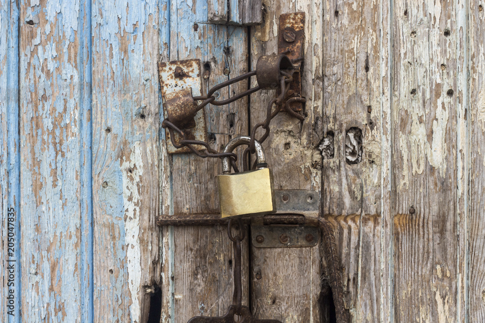 Lock with a chain on an old wooden door Lock with a chain on an old wooden door