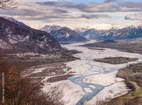 The slow flow of the Tagliamento river cradled by its mountains.