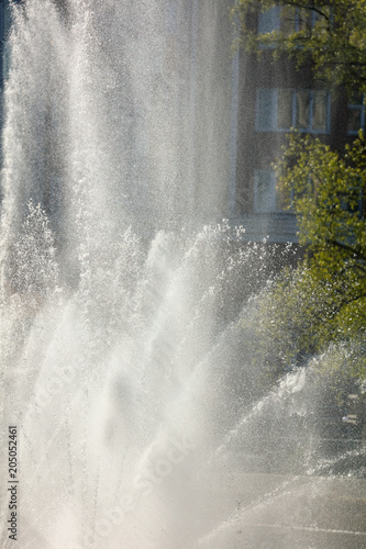 Spray from the fountain in the city as a background