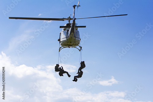 Special forces in helicopter with blue sky on background