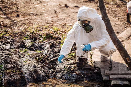 female collects soil in a test tube. soil analysis, environment, ecology concept.