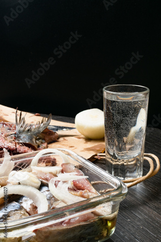 Ukrainian Russian national snack - onions, pickled herring Delicious organic appetizer. With a glass of vodka photo