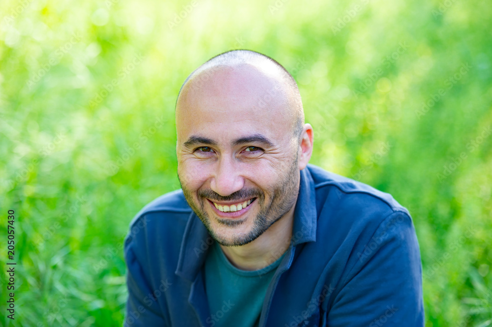face of a bearded smiling bald man in the park. face of a bearded smiling bald man in the park.