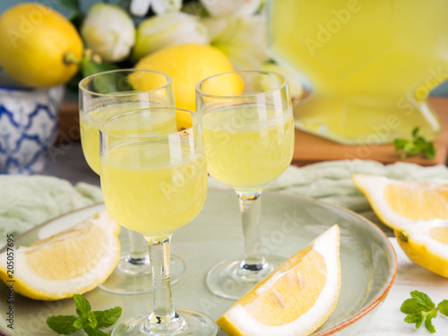 Fotografi Home made limoncello served in stemmed glasses. Summer still life