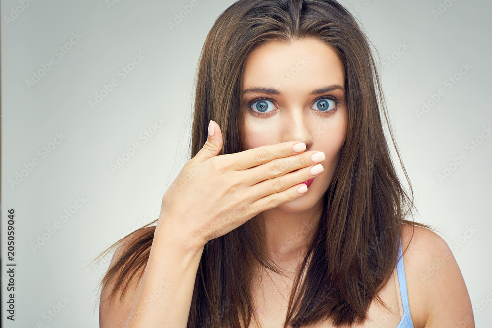 Close up face portrait of surprising woman covering mouth with h Close up face portrait of surprising woman covering mouth with h