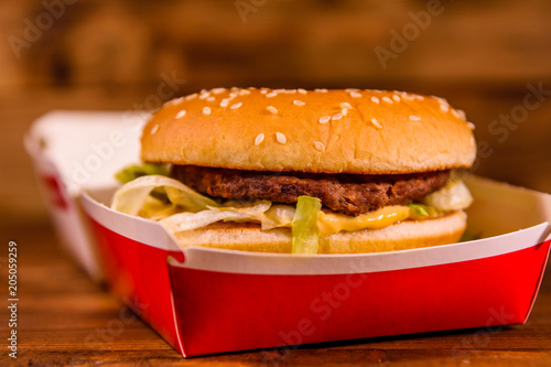 Fresh hamburger in paper box on the rustic wooden table