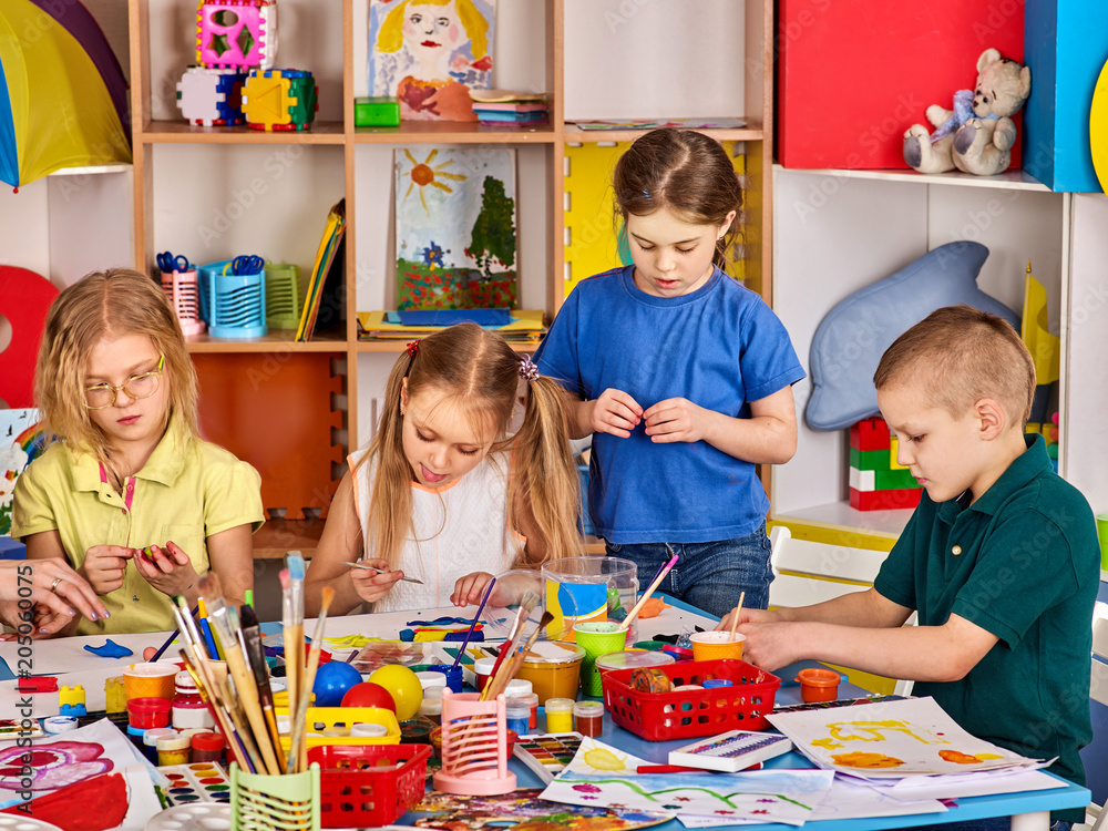 Plasticine modeling clay in children class. kids together play dough and  mold from plasticine in kindergarten or preschool. Group of four people.  Teaching modeling. Stock Photo