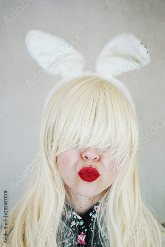 Mujer joven y rubia que lleva puestas unas orejas de conejo  photo