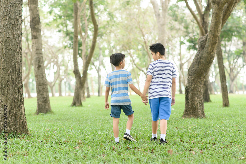 Two boy hold their hand and walk